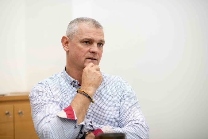 Arnaud Lagesse listening in conversation, hand resting against his chin