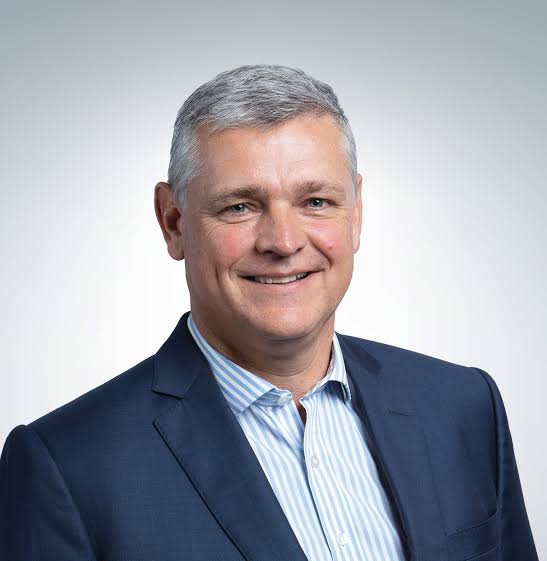 Corporate headshot of Arnaud Lagesse in a navy jacket and striped shirt