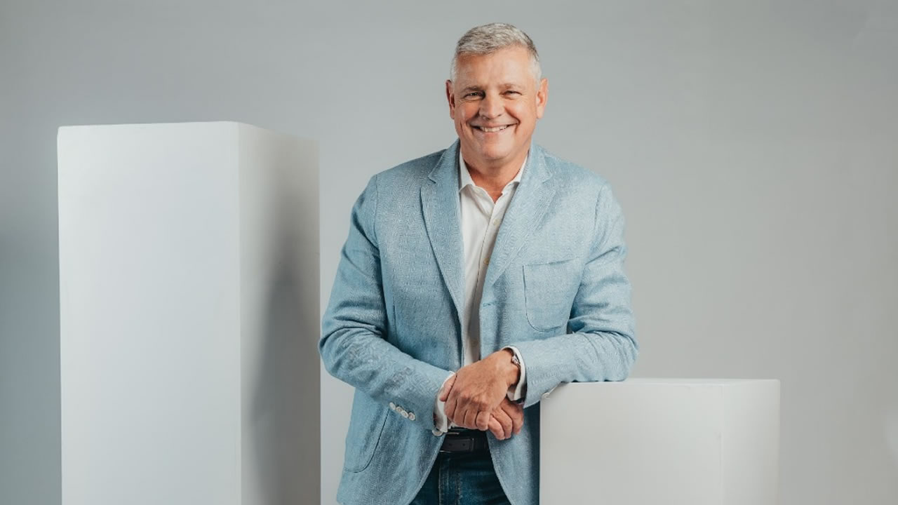 Arnaud Lagesse photographed in a light studio setting wearing a pale blue jacket
