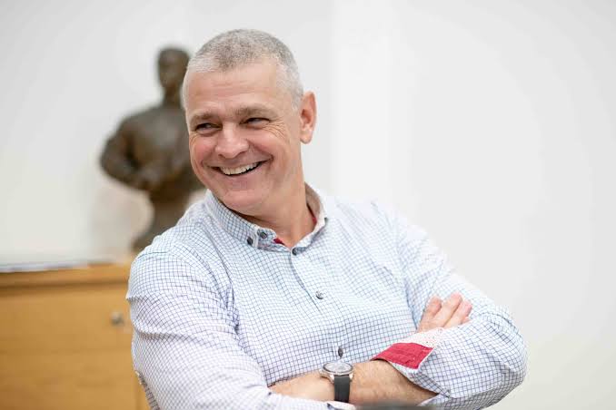 Arnaud Lagesse laughing with his arms folded in a relaxed office setting